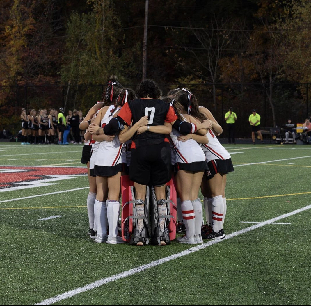Members of the field hockey team gather for a huddle before a recent game.