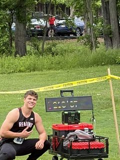 Luke Rogerson ('26) with a scoreboard that shows his D3 state championship winning throw.